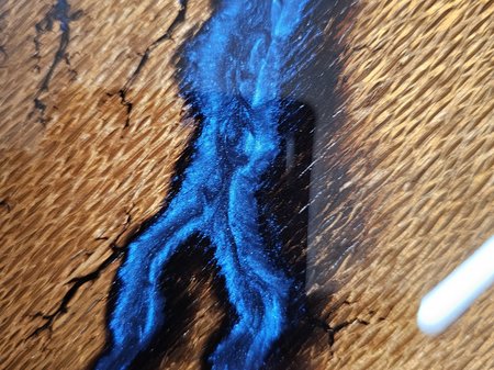 Close up of bright blue resin on a wooden chopping board