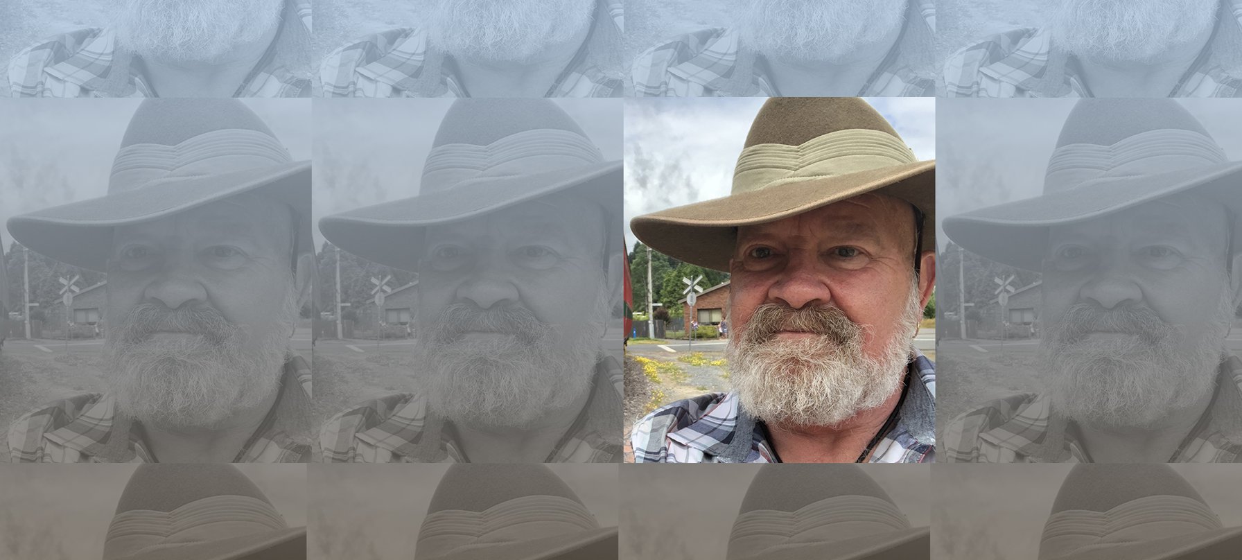 A photo of Bob Cartledge wearing a sturdy felt hat and a black and white flannelette shirt. Bob has a grey and white beard that extends past his chin, pale skin, blue eyes and smile lines beside his eyes. Credit Bob Cartledge.