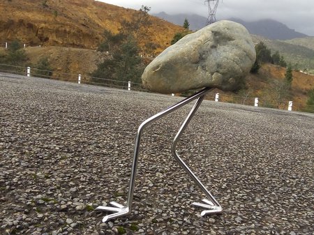 A photo of Colin Wilson's work - a small rock with metal legs is positioned to look as though is is walking up a hill. Credit Colin Wilson.