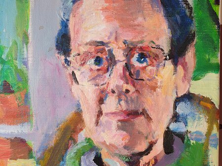 A photo of Jenny Groves' work. The work is a painted canvas portrait of a person with pale skin, short grey hair, blue eyes and wide-framed glasses. The scene behind the person features bright greens framed by windows. Credit Sebastian Haquin.