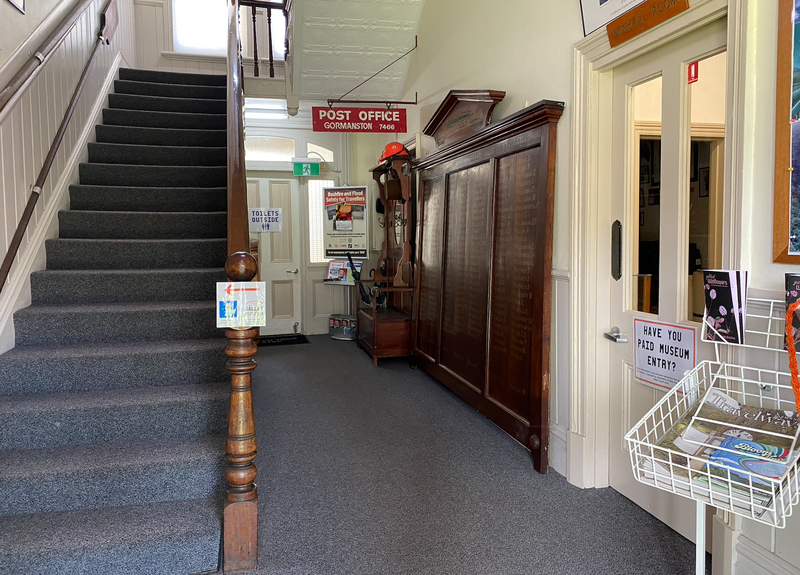 A photo taken through the front entrance of The Galley Museum showing a staircase to the left.