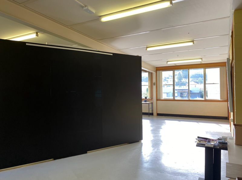 A photo of the gallery space inside PressWEST. The gallery space has shiny smooth concrete floors and natural lighting.