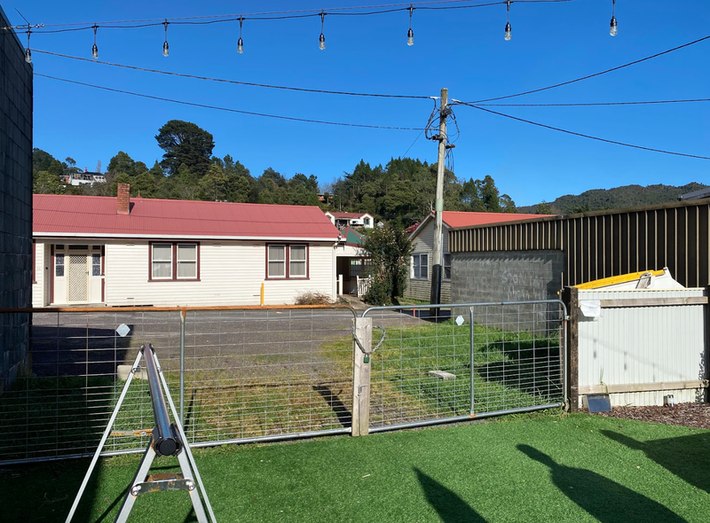 A photo taken from inside the beer garden at Moonscape Wine Bar and Cafe, facing the fence that leads from the garden out onto Little Orr Street.