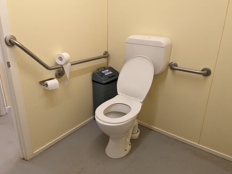 A photo of the toilet and handrails inside the accessible bathroom at Queenstown Football Ground..