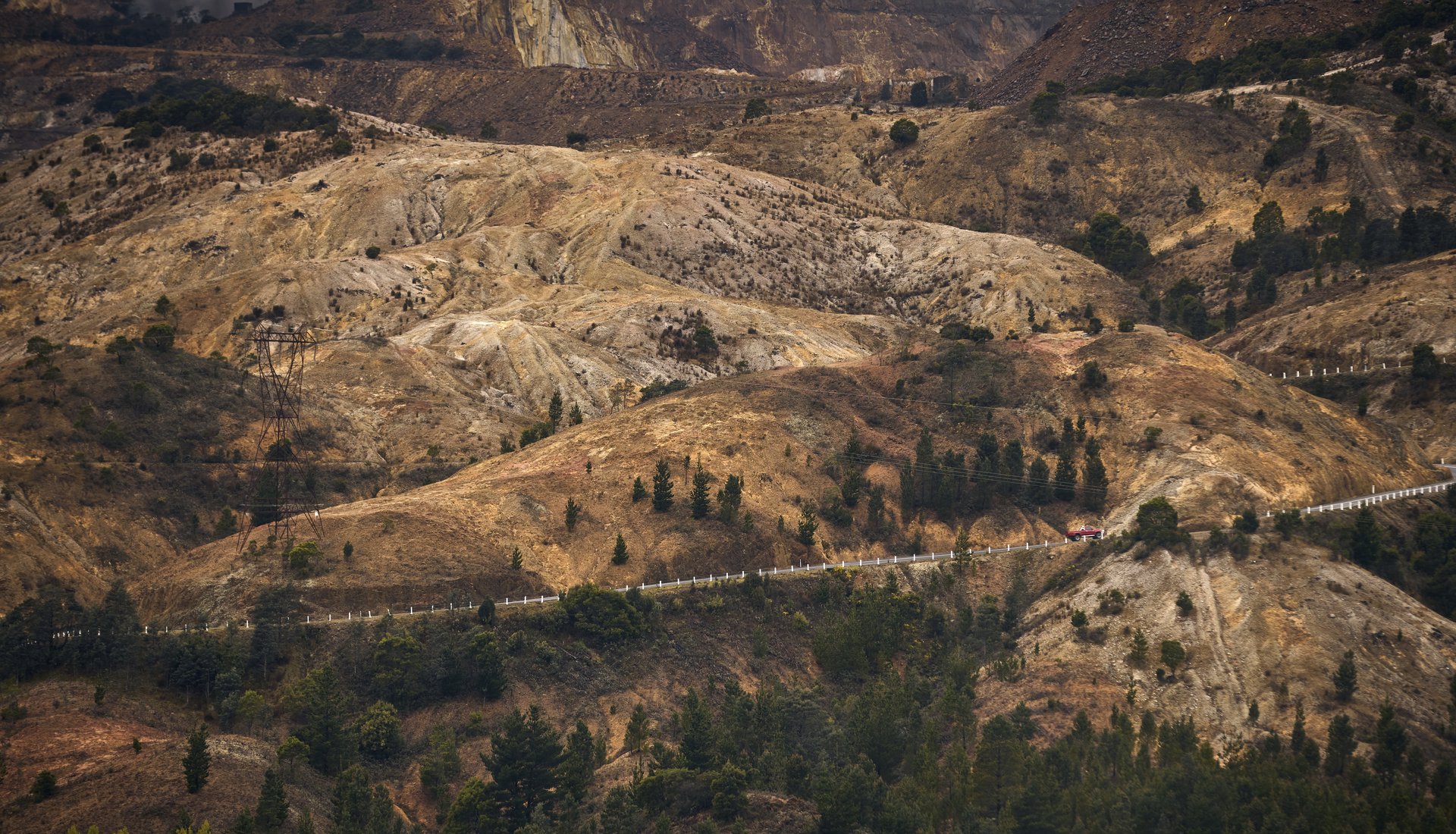 A photo of the rugged hills of Queenstown, with the 99 Bends highway winding throughout. By Rémi Chauvin