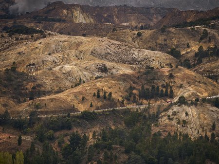 A photo of the rugged hills of Queenstown, with the 99 Bends highway winding throughout. By Rémi Chauvin