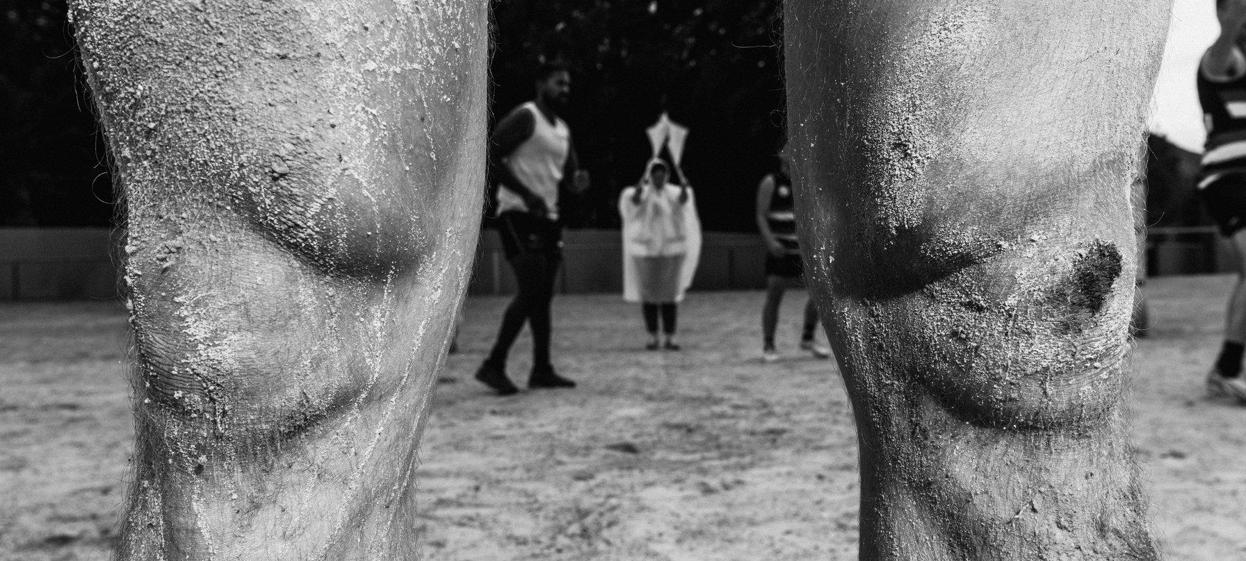 The Unconformity Cup. A black and white photo of two dirty and bloody knees. Credit Jesse Hunniford.